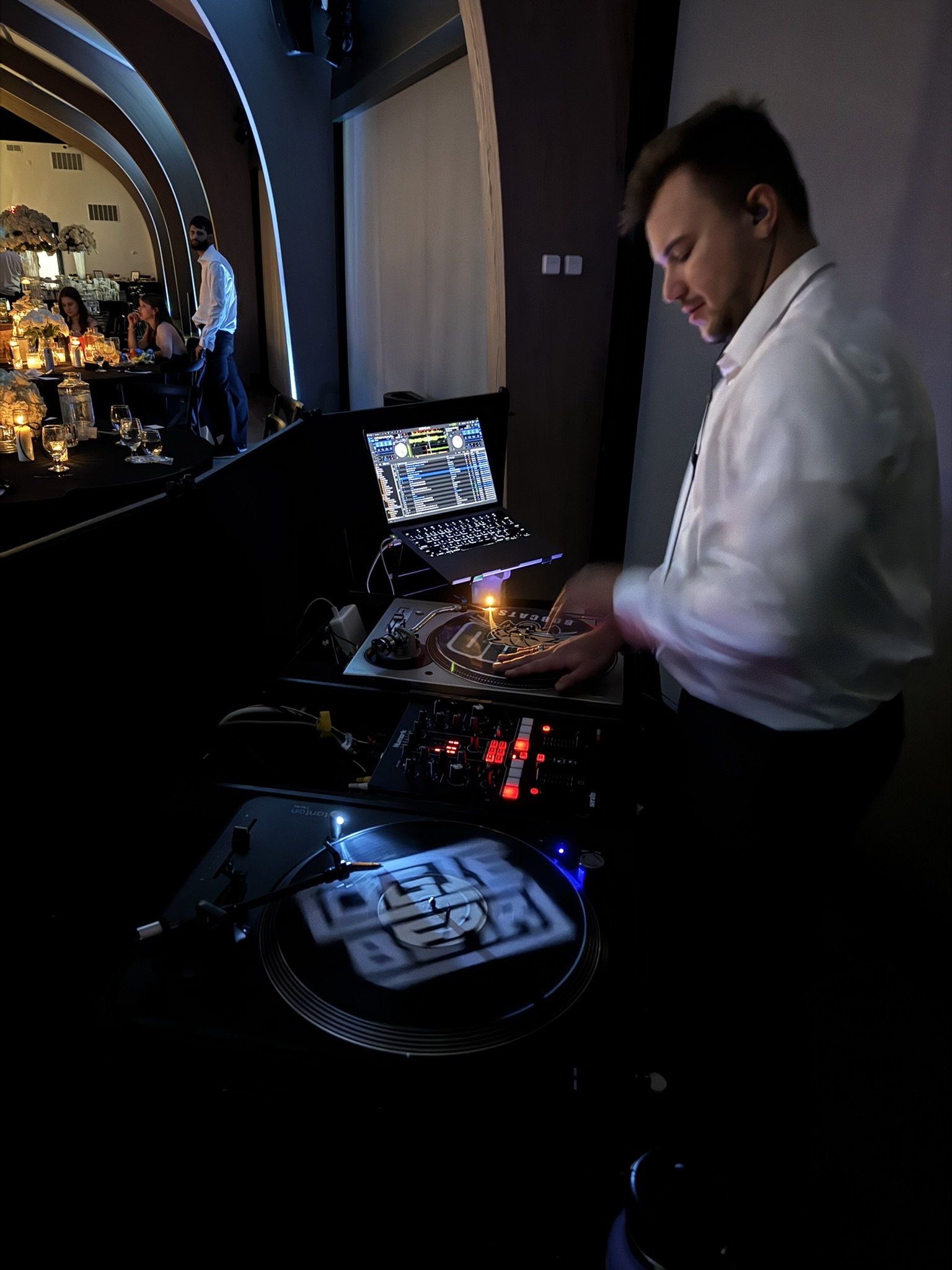 Packed wedding dance floor in mid-reception with the DJ working the room