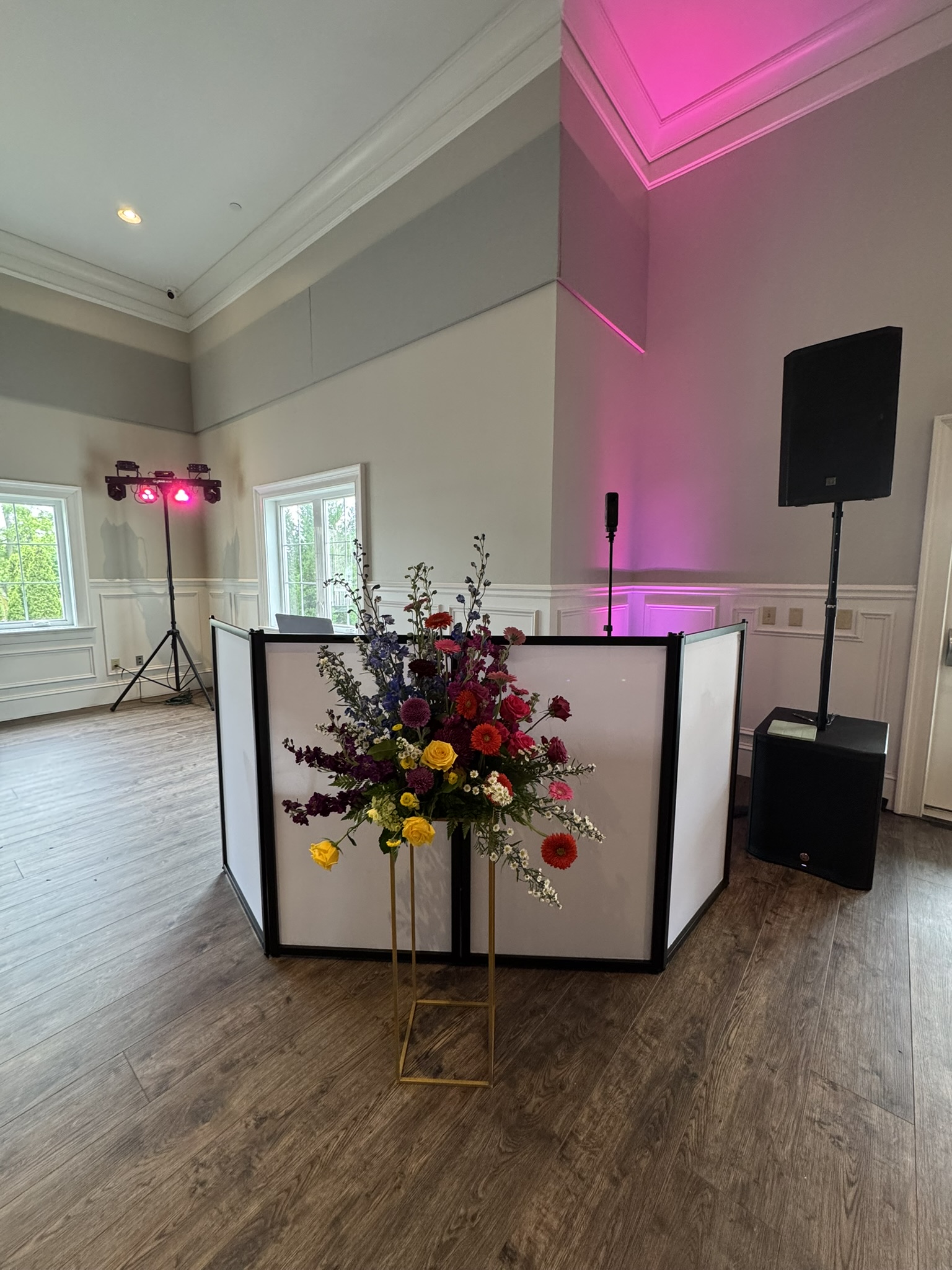 DJ booth with PA speaker and pink uplighting set up at a Columbus event