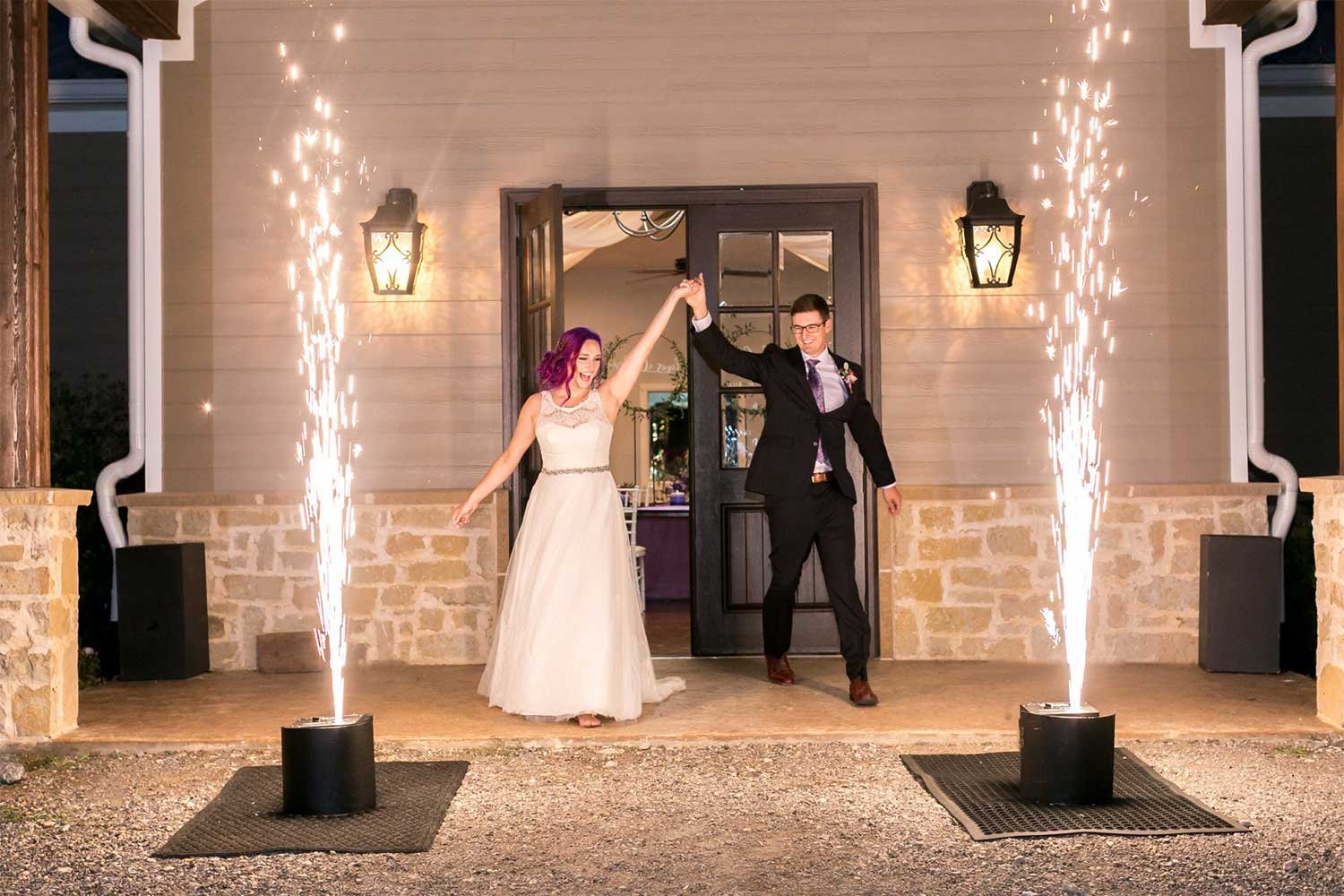 Newlyweds making a grand entrance flanked by twin cold-spark fountains